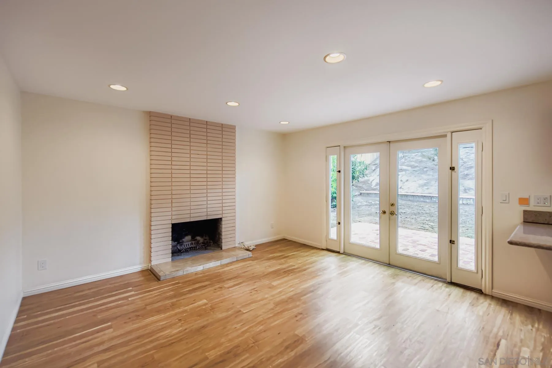 5977 Agee Street San Diego, CA 92122 - Photo 10 of 25 an empty room with wooden floor fireplace and windows