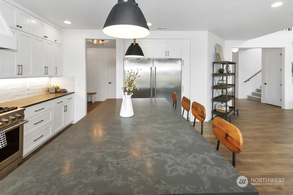 12243 Mundy Loss Road Buckley, WA 98321 - Photo 23 of 40 a large kitchen with stainless steel appliances kitchen island granite countertop a refrigerator a stove and a sink