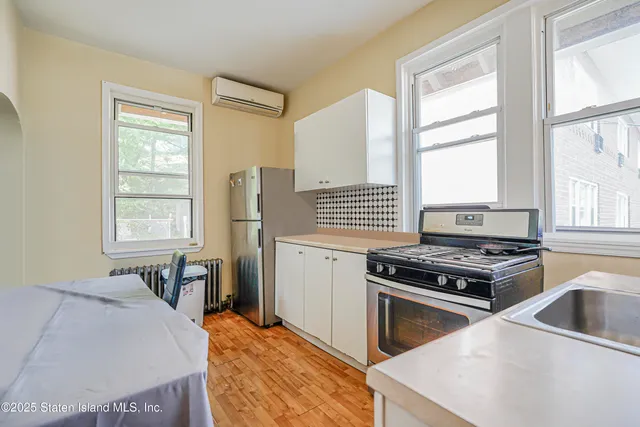 a kitchen with a stove a sink and a window