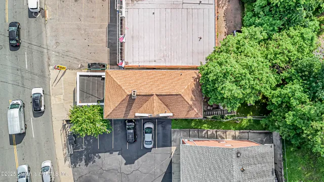 aerial view of a house with a yard and potted plants