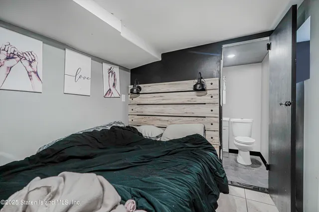 a bedroom with a bed and a painting on the wall