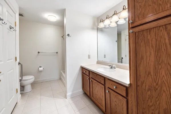 a bathroom with a double vanity sink mirror and toilet