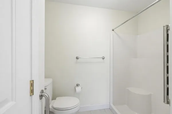 a white toilet sitting next to a shower