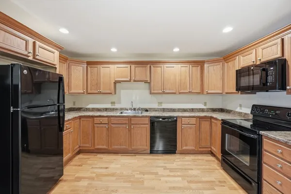 a modern kitchen with granite countertop stainless steel appliances and wooden cabinets