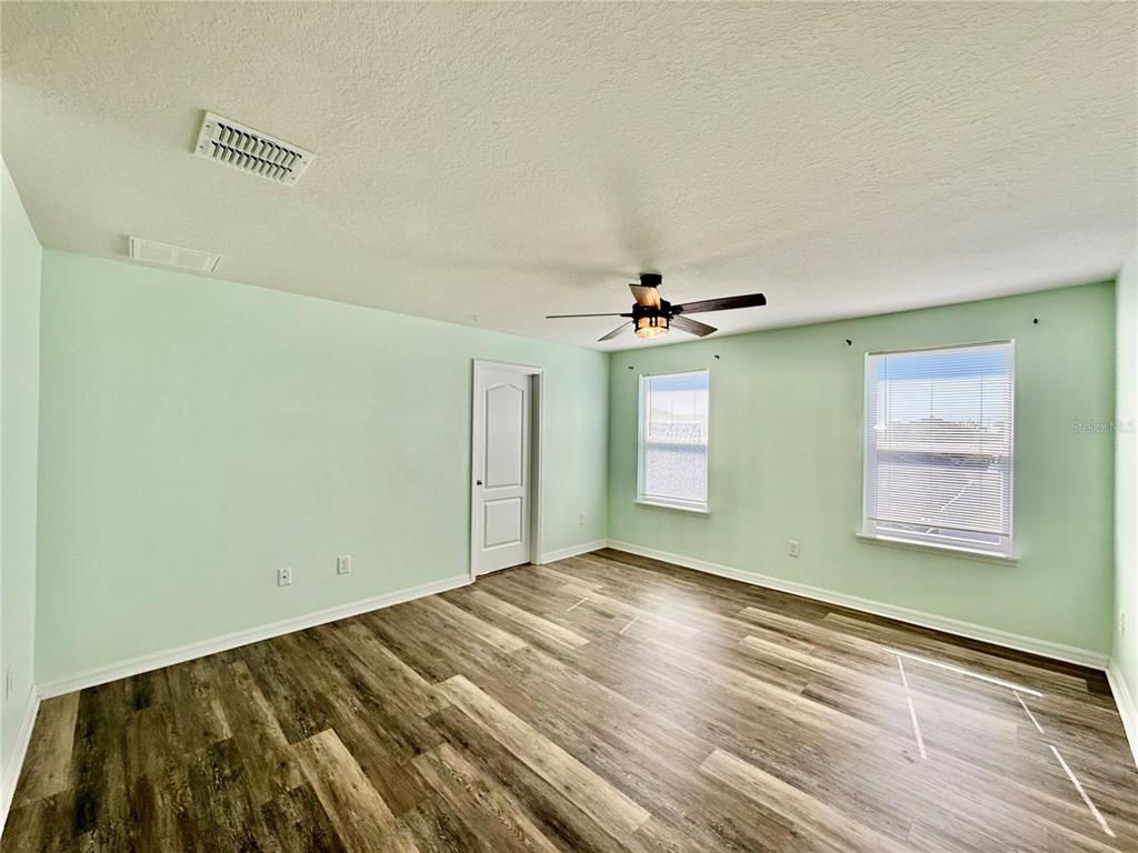 14207 Poke Ridge Drive Riverview, FL 33579 - Photo 17 of 34 a view of a room with wooden floor ceiling fan and windows