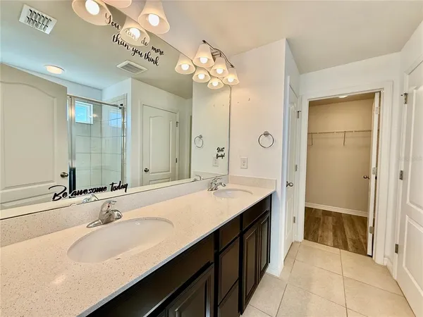 a bathroom with a sink double vanity granite tub and a mirror