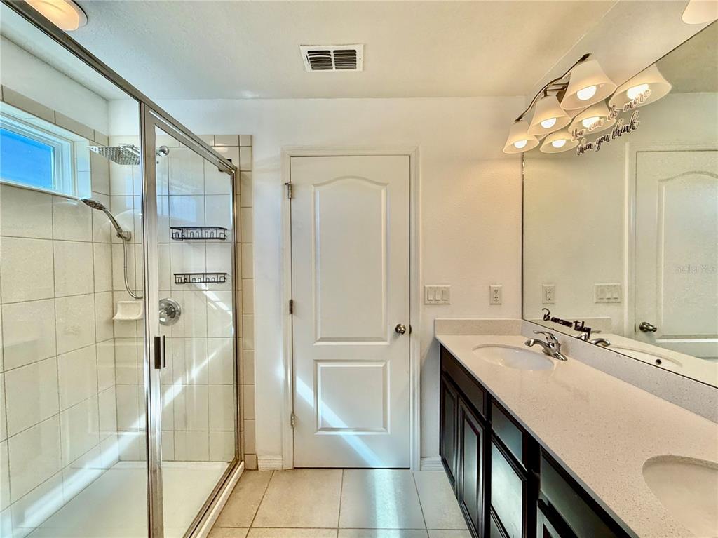 14207 Poke Ridge Drive Riverview, FL 33579 - Photo 19 of 34 a bathroom with a double vanity sink a mirror and a shower