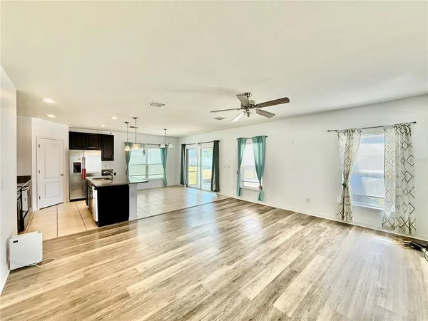 a view of a big room with wooden floor and windows