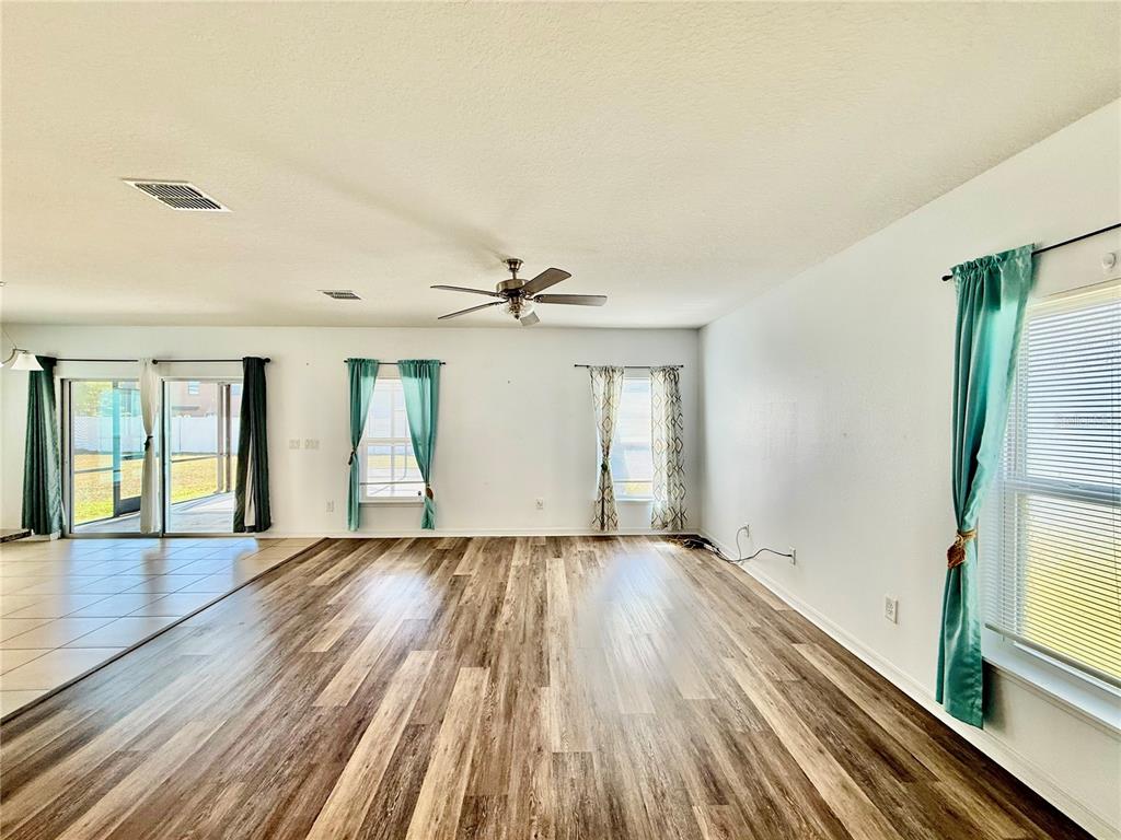 14207 Poke Ridge Drive Riverview, FL 33579 - Photo 4 of 34 an empty room with wooden floor cabinet and windows