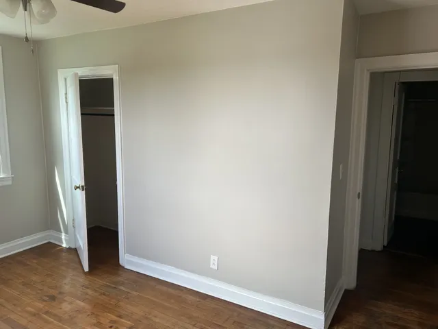 an empty room with wooden floor and closet