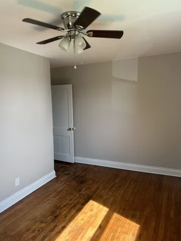 a view of a room with wooden floor and fan