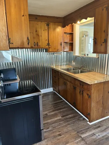 a view of kitchen with a sink and wooden cabinets