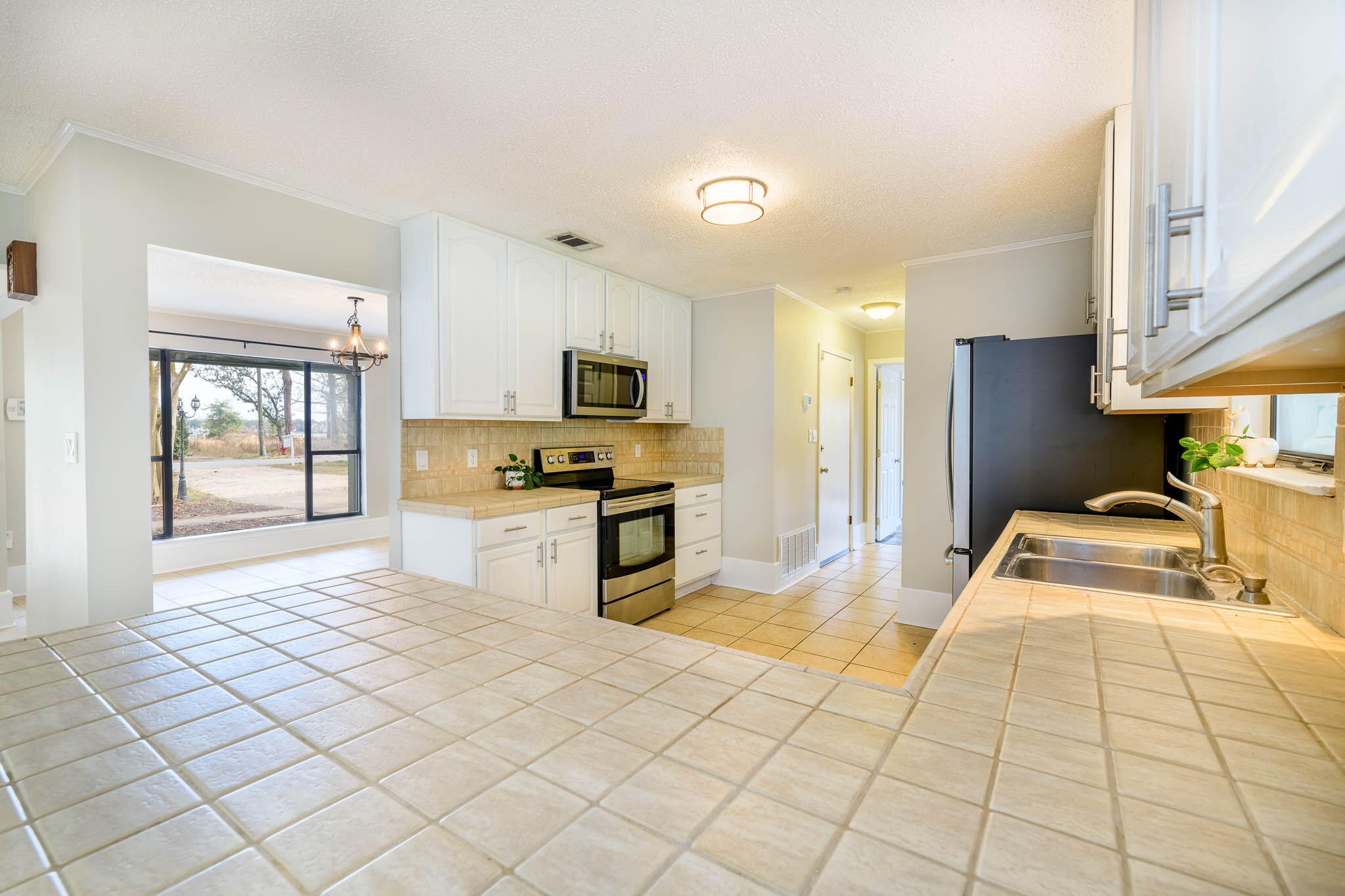 1688 Vine Avenue Niceville, FL 32578 - Photo 15 of 32 a large white room with kitchen view and wooden floor