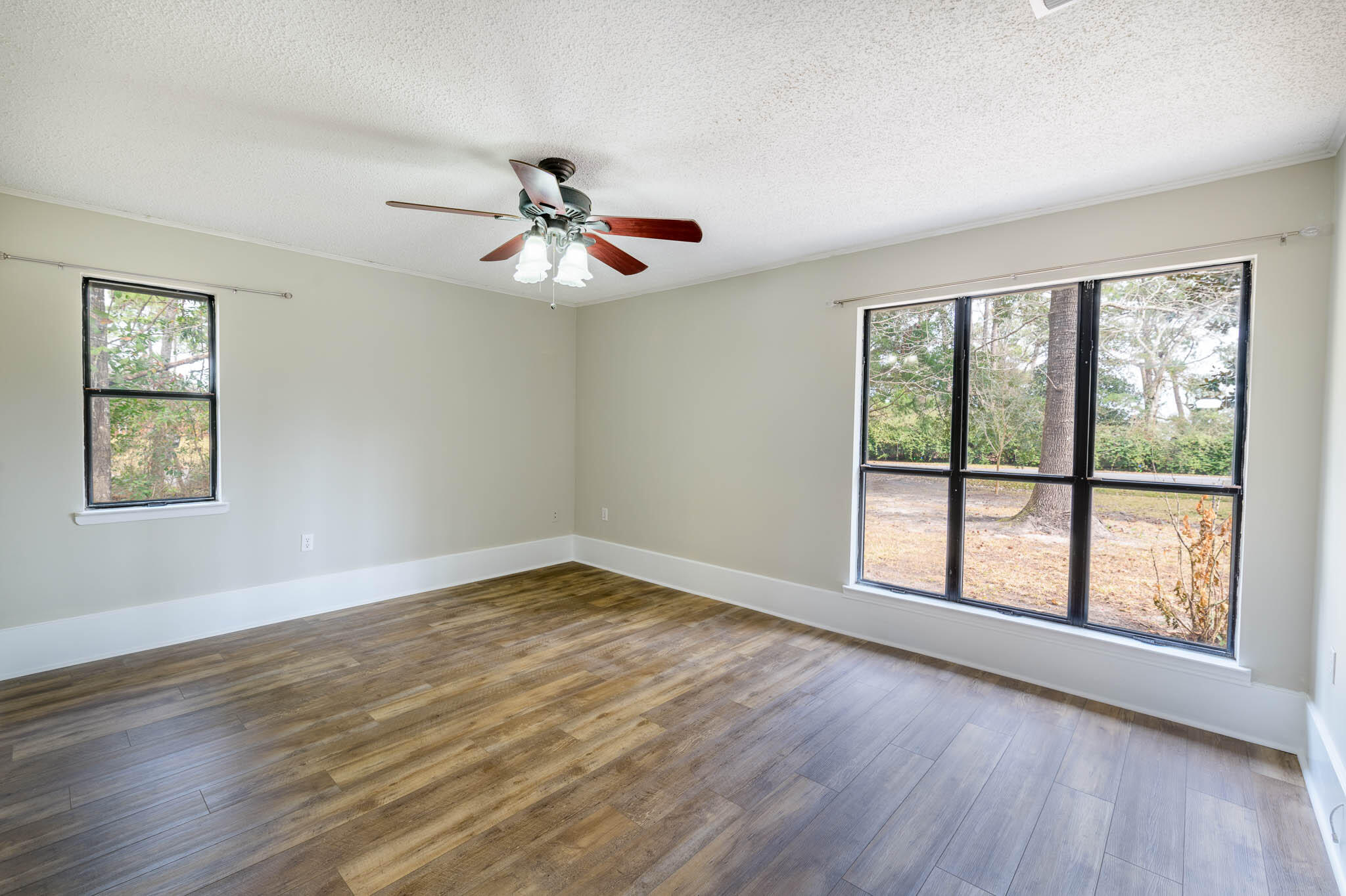 1688 Vine Avenue Niceville, FL 32578 - Photo 19 of 32 a view of an empty room with wooden floor and a window