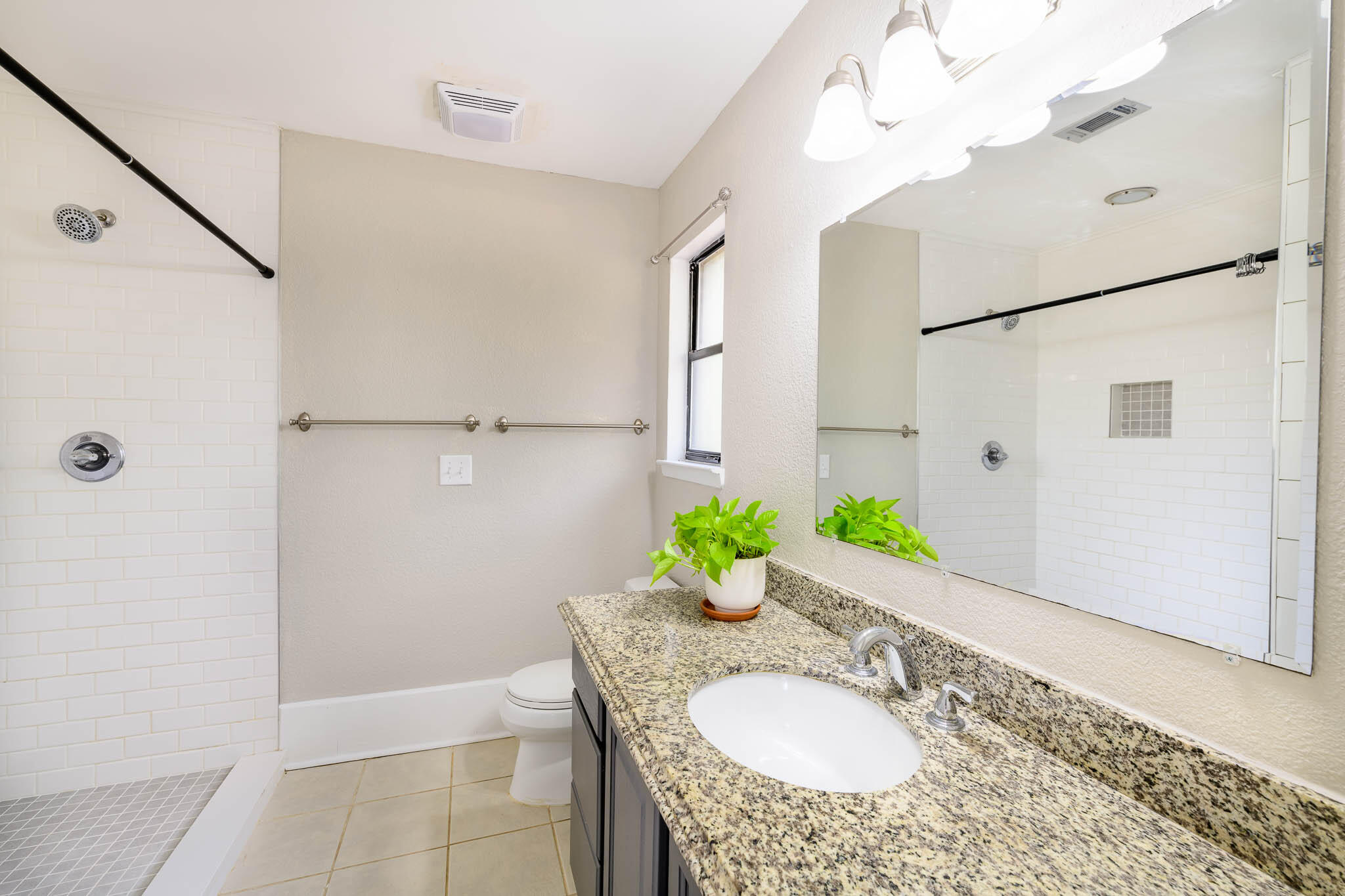 1688 Vine Avenue Niceville, FL 32578 - Photo 21 of 32 a bathroom with a granite countertop shower a sink and a mirror