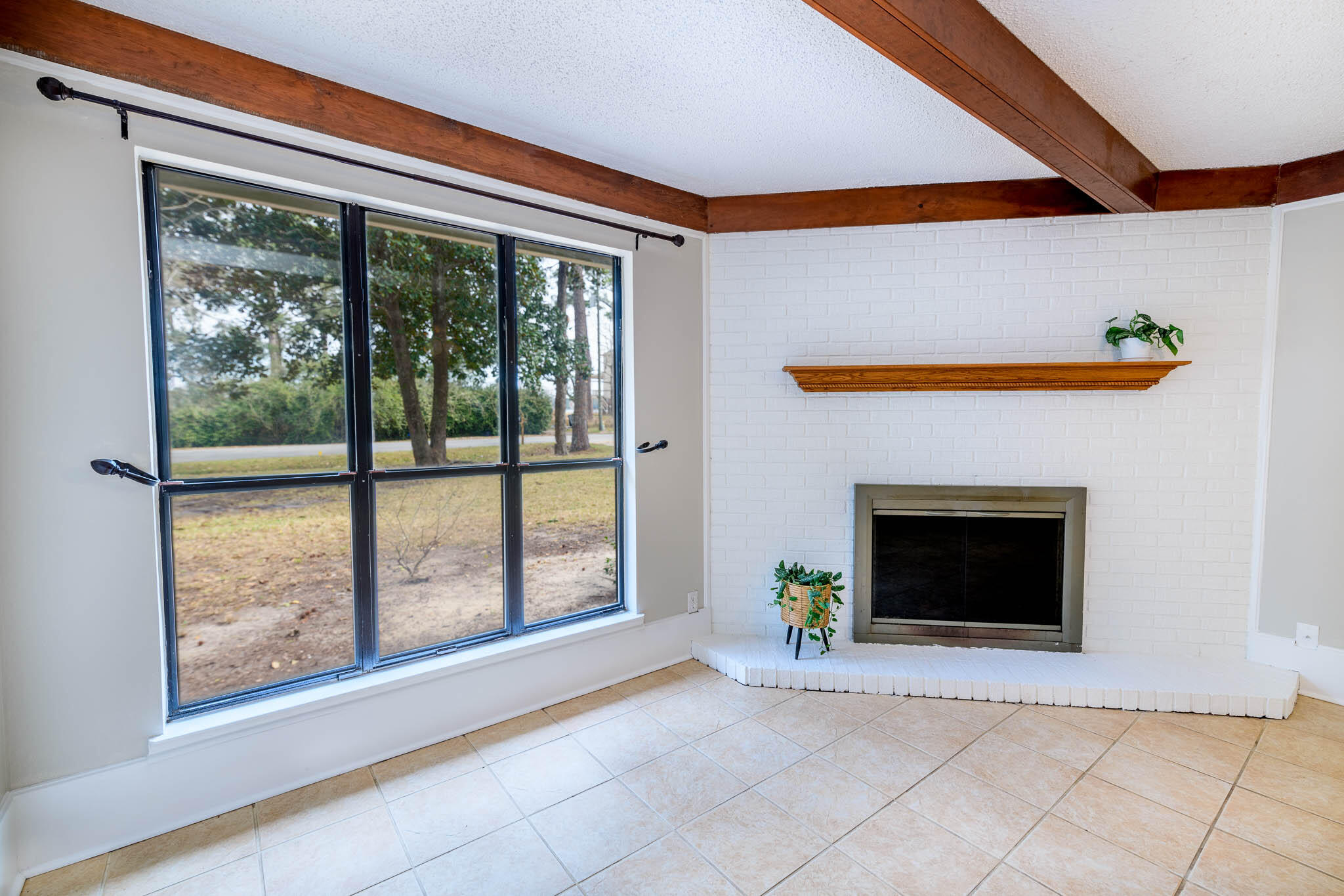 1688 Vine Avenue Niceville, FL 32578 - Photo 9 of 32 a view of an empty room with a fireplace and a window