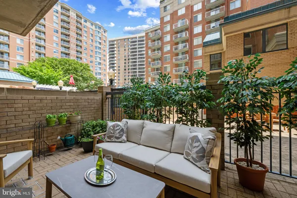 a view of a patio with couches table and chairs and potted plants