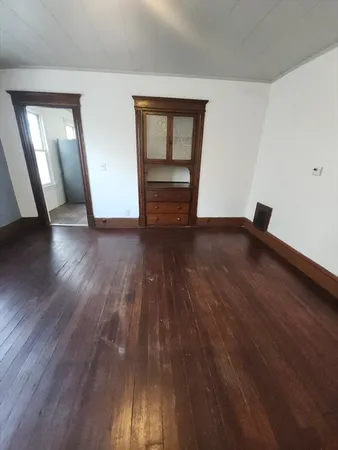 wooden floor in an empty room with a window