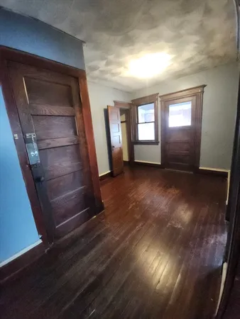 a view of an empty room and wooden floor and a window