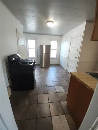 a kitchen with granite countertop a refrigerator and a stove