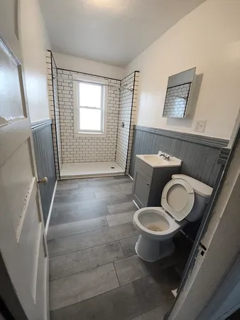 a bathroom with a toilet sink and mirror