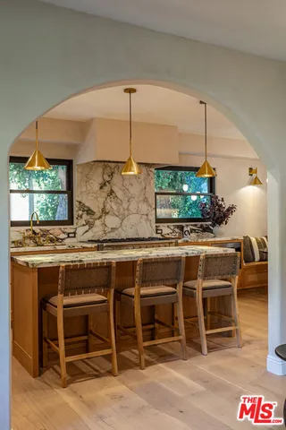 a kitchen with stainless steel appliances kitchen island a table and chairs in it