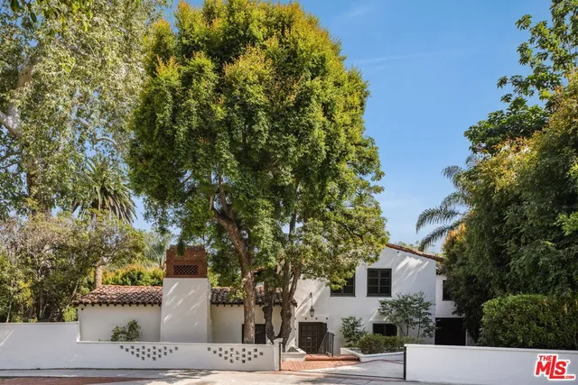 a view of a white house with a street