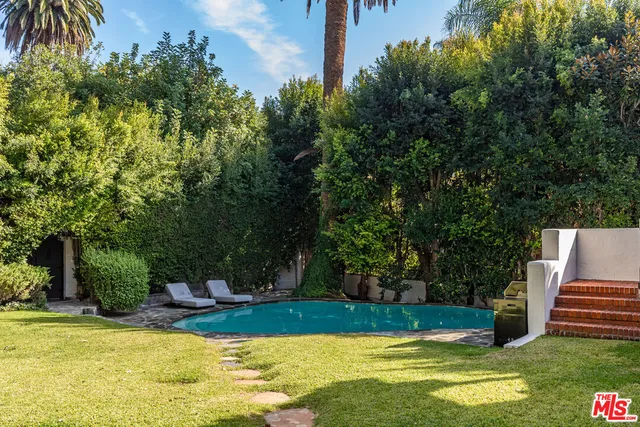 a front view of a house with swimming pool having outdoor seating