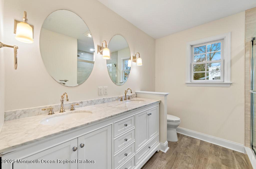 495 Branch Avenue Little Silver, NJ 07739 - Photo 18 of 26 a bathroom with a granite countertop sink a toilet and a mirror
