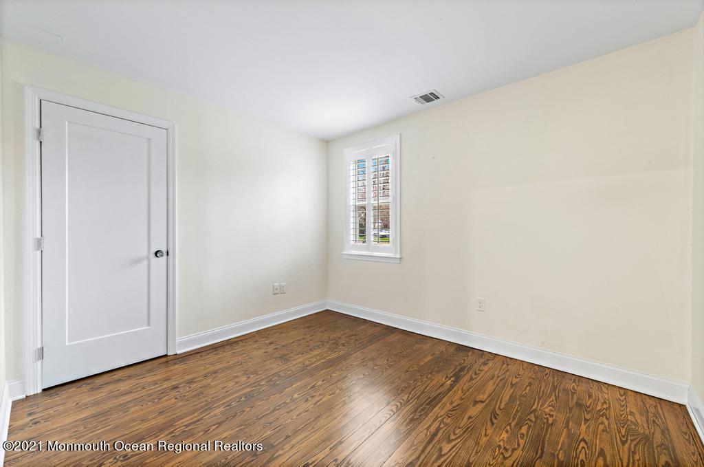 495 Branch Avenue Little Silver, NJ 07739 - Photo 23 of 26 a view of an empty room with wooden floor and a window