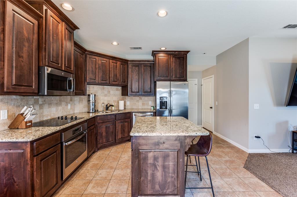 508 Copenhavr Street Pilot Point, TX 76258 - Photo 12 of 25 a kitchen with stainless steel appliances granite countertop a sink counter space cabinets and a refrigerator
