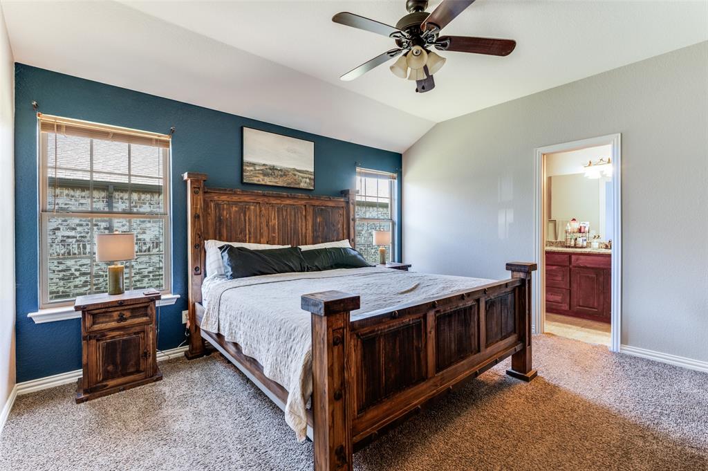 508 Copenhavr Street Pilot Point, TX 76258 - Photo 13 of 25 a bed room with a bed and a chandelier