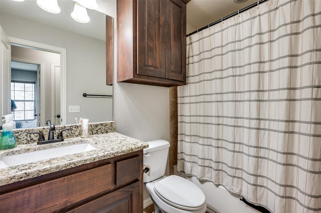 508 Copenhavr Street Pilot Point, TX 76258 - Photo 20 of 25 a bathroom with a granite countertop toilet sink and mirror