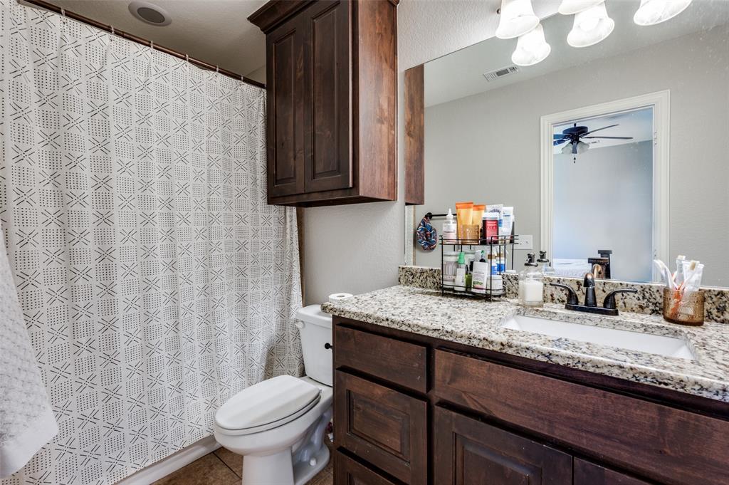 508 Copenhavr Street Pilot Point, TX 76258 - Photo 21 of 25 a bathroom with a granite countertop sink and a toilet