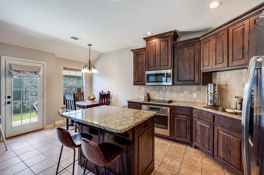 508 Copenhavr Street Pilot Point, TX 76258 - Photo 9 of 25 a kitchen with granite countertop a sink and wooden cabinets