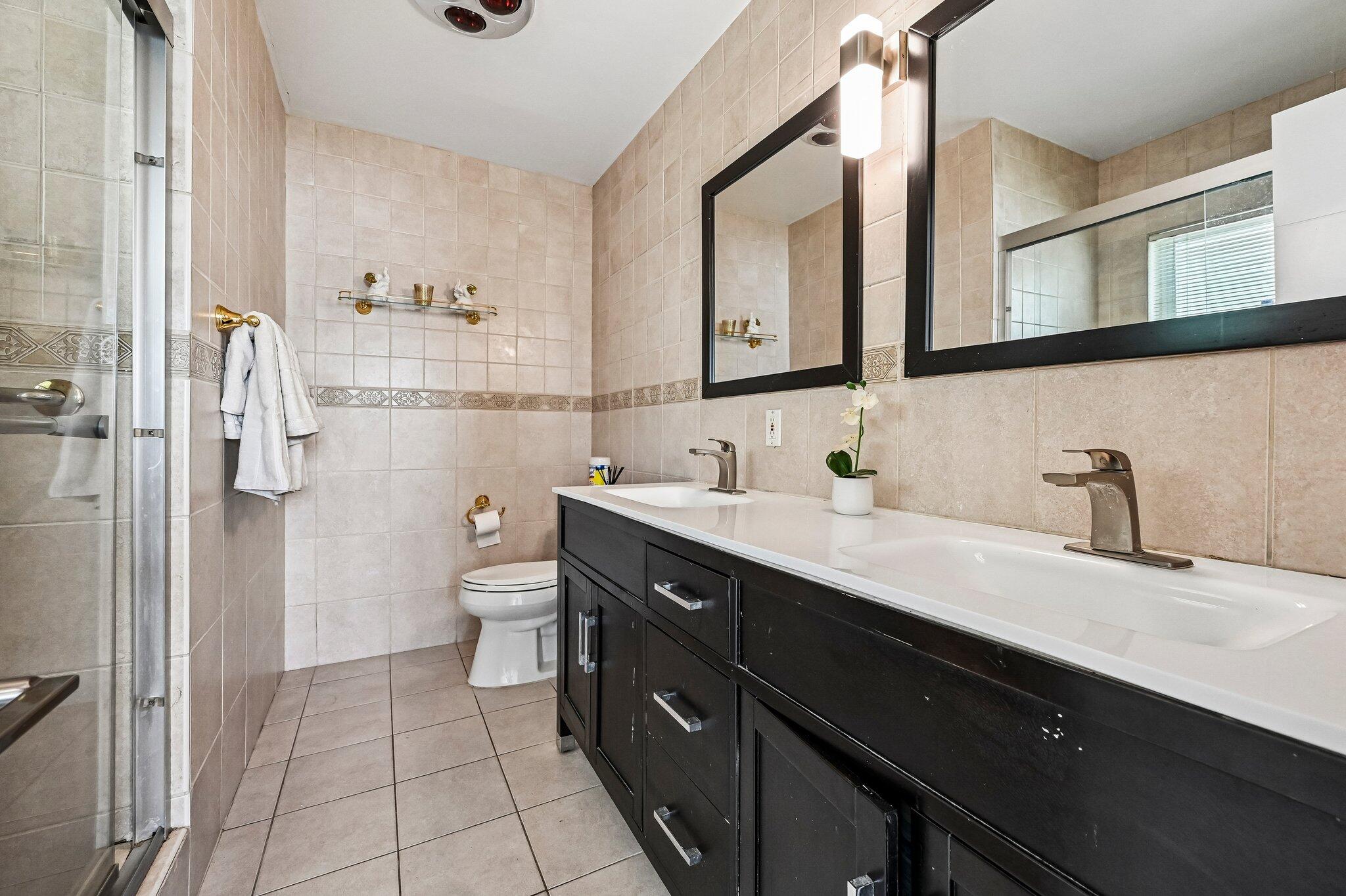 2940 Northeast 39th Court Lighthouse Point, FL 33064 - Photo 20 of 42 a bathroom with a double vanity sink a toilet and a mirror