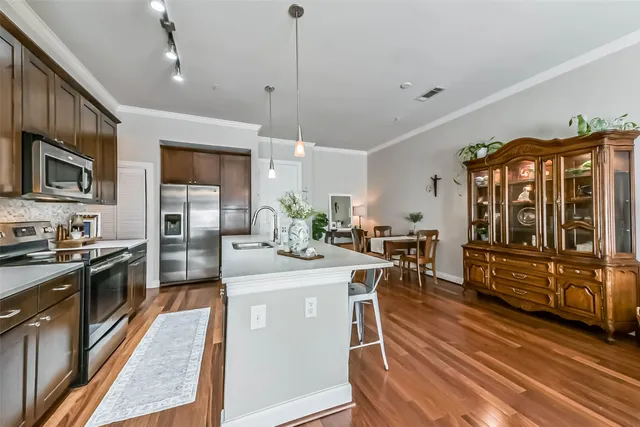 a kitchen with kitchen island a sink stove and refrigerator with wooden floor