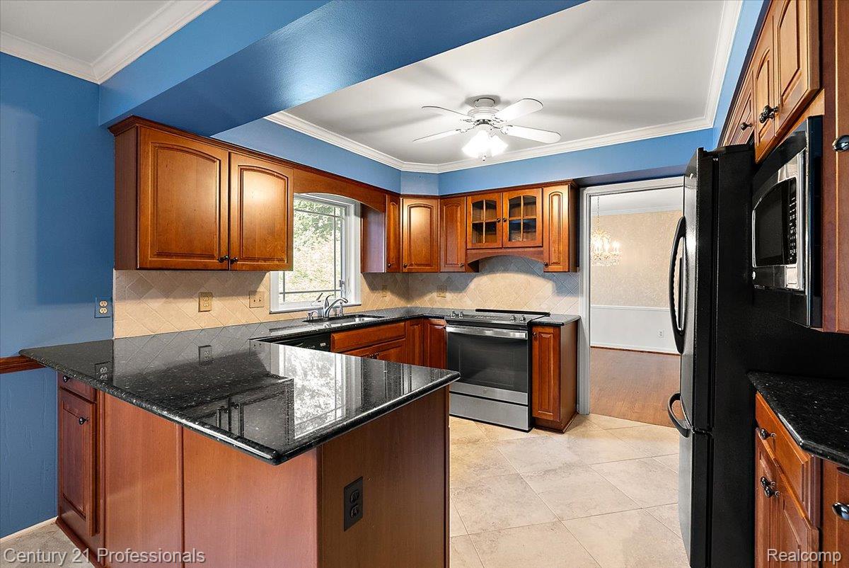 633 Foxhall Road Bloomfield Hills, MI 48304 - Photo 32 of 61 Kitchen featuring wood cabinetry, dark countertops, a built-in microwave, and tile flooring