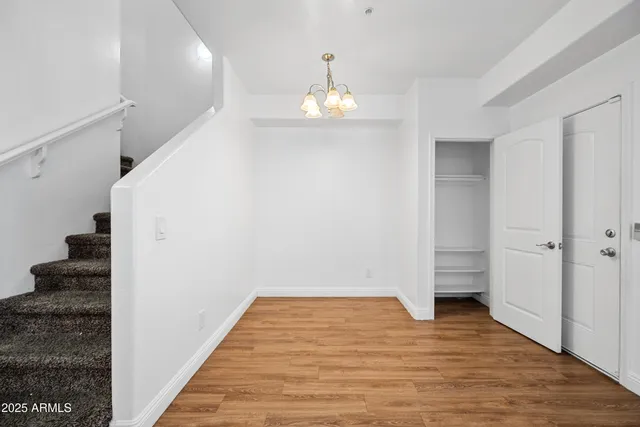 a view of a big room with wooden floor closet and windows