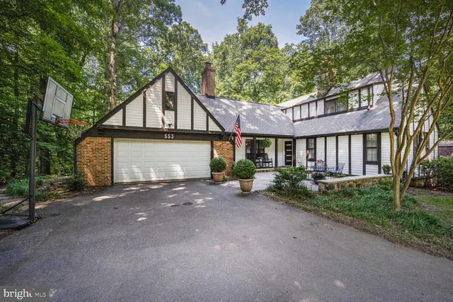 a view of a house with a yard and large tree