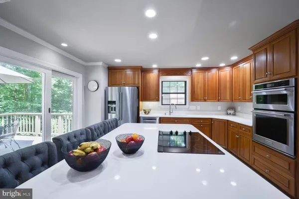 a kitchen with stainless steel appliances granite countertop a refrigerator a sink and a stove