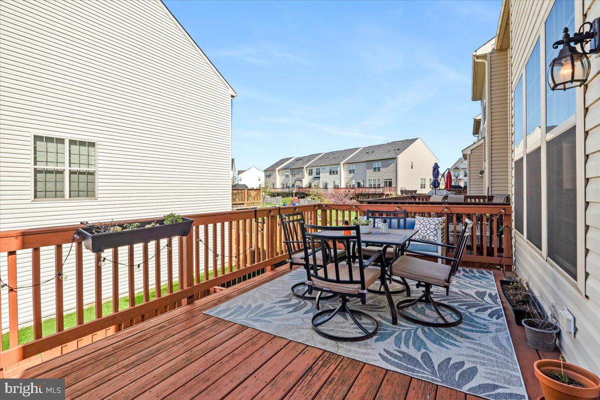 6500 Newton Drive Frederick, MD 21703 - Photo 31 of 36 a view of a roof deck with table and chairs and wooden floor