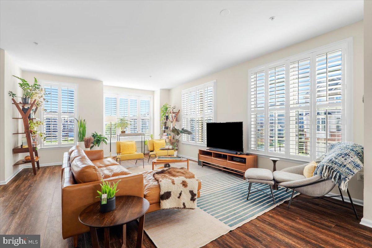6500 Newton Drive Frederick, MD 21703 - Photo 10 of 36 a living room with furniture floor to ceiling window hardwood floor and a flat screen tv