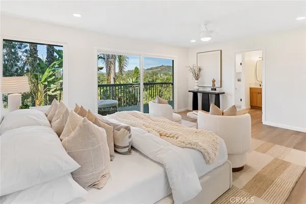 a bed sitting in a spacious bedroom next to a large window