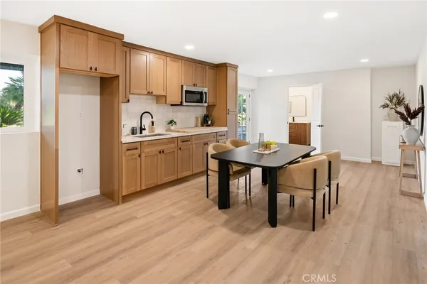 a kitchen with granite countertop a table chairs stove a sink and refrigerator