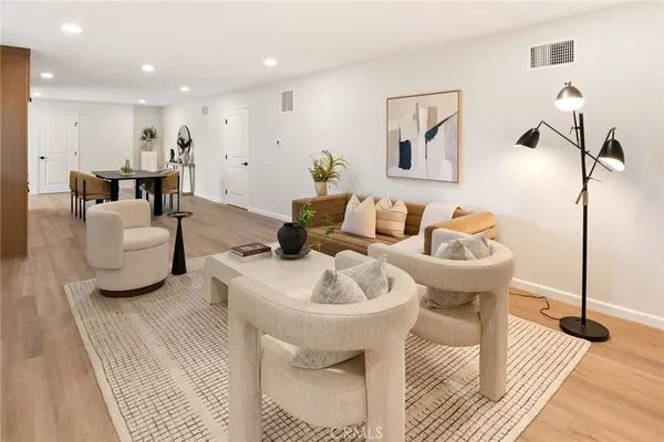 a living room with furniture a rug and white walls