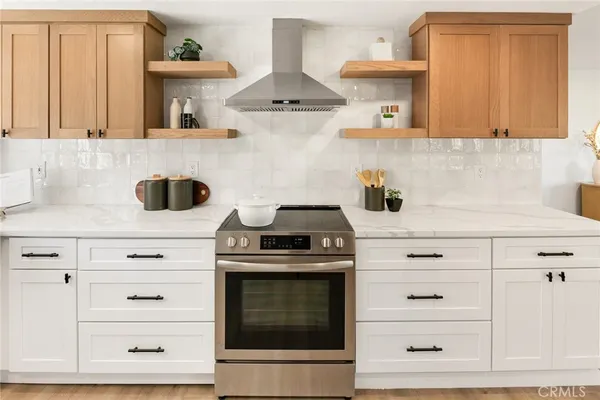 a kitchen with stainless steel appliances granite countertop white cabinets and a stove