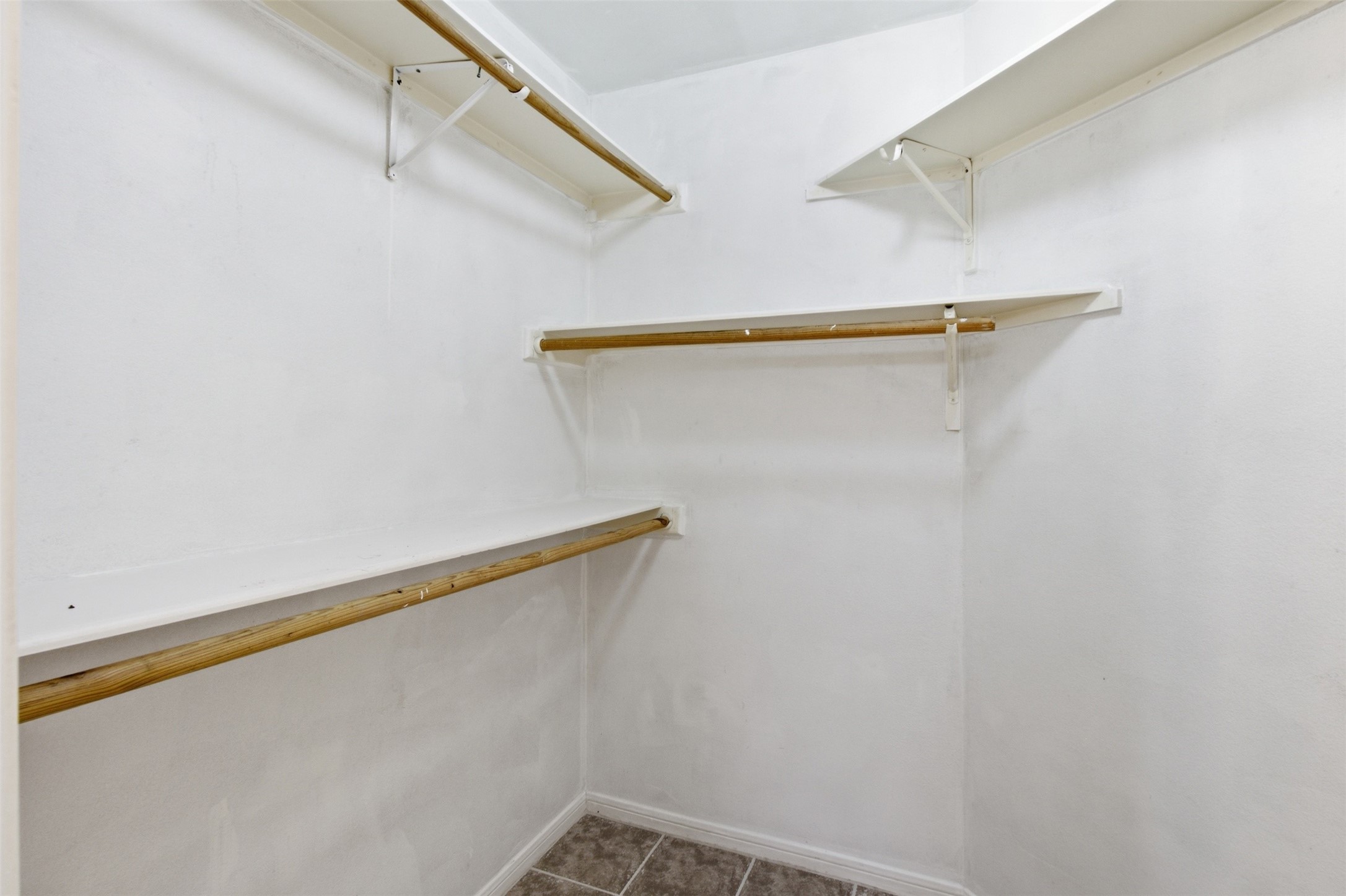 15738 Boonridge Road Houston, TX 77053 - Photo 22 of 31 Spacious walk-in closet with ample shelving and hanging space, perfect for organized storage.
