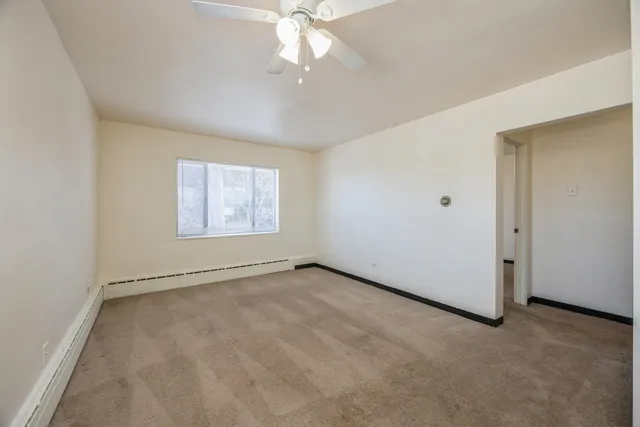 an empty room with fan and windows