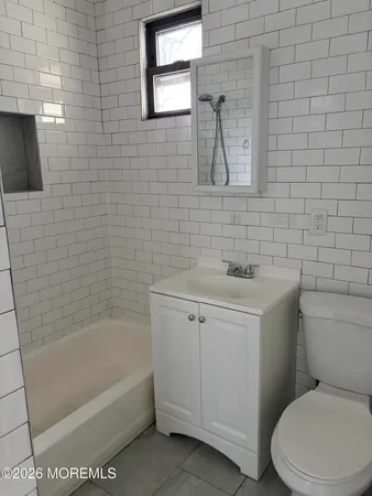 a bathroom with a white toilet sitting next to a bathtub